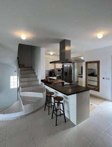 a kitchen with a counter and some stools in it at Costa Adeje Villa Private pool Panoramic Views in Adeje