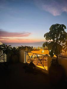 een balkon met palmbomen en uitzicht op de zonsondergang bij Costa Adeje Villa Private pool Panoramic Views in Adeje