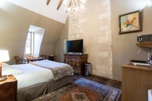 a bedroom with a large bed and a tv at L'Hôtel de Panette - La Charpente climatisée Renaissance - cathédrale in Bourges