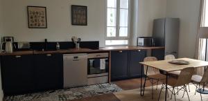 a kitchen with blue cabinets and a table with chairs at Domaine et Manoir du Picaud in Monestier