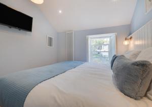 a bedroom with a large bed with a television on the wall at The Old Bakery in Newlyn