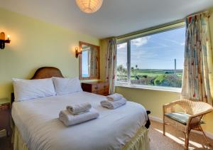 a bedroom with a bed with towels on it at Chy An Porth in Padstow