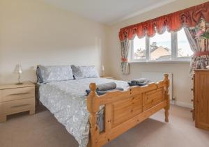 a bedroom with a wooden bed and a window at Bishops Hill in Acomb