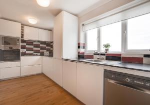 a kitchen with white cabinets and a window at Bishops Hill in Acomb