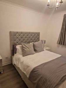 a bedroom with a large bed with a large headboard at Flat in Hamilton, South Lanarkshire in Hamilton