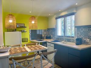 a kitchen with blue and green walls and a counter top at LES TERRASSES DE VALERIAN in Brignoles