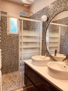 een badkamer met 2 wastafels en een spiegel bij LES TERRASSES DE VALERIAN in Brignoles