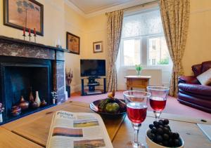 a living room with a table with two glasses of wine at Sammys Place in Hexham