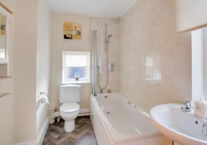 a bathroom with a toilet and a tub and a sink at Sammys Place in Hexham