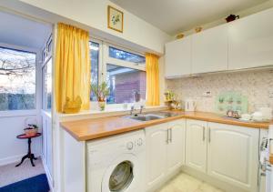 a kitchen with a washing machine and a sink at Endar in Tweedmouth