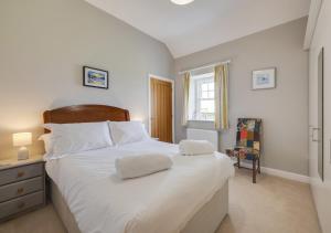 a bedroom with a large white bed with two towels on it at The Barns in Ellingham