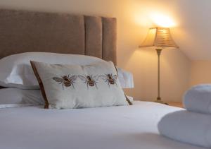 ein Bett mit zwei Kissen mit Bienen drauf in der Unterkunft Hethpool Mill in Kirknewton