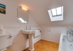 a white bathroom with a sink and a mirror at Hethpool Mill in Kirknewton