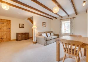 ein Wohnzimmer mit einem Tisch und einem Sofa in der Unterkunft Hethpool Mill in Kirknewton