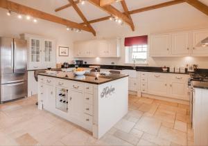 a kitchen with white cabinets and a large island at The Barns in Ellingham