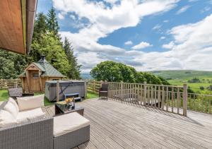 a wooden deck with a couch and chairs on it at Mount Hooley Lodge in Alston