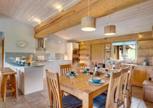 Il comprend une cuisine et une salle à manger avec une table et des chaises en bois. dans l'établissement Mount Hooley Lodge, à Alston