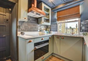 a kitchen with a sink and an oven at Park View Cottage in Kirkby Malzeard
