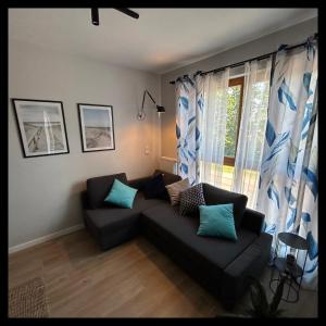 uma sala de estar com um sofá e uma janela em Apartament Walizka em Gdansk