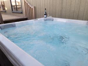 a hot tub with a bottle of wine in it at Silverwood Luxury Lodges & Bistro Barn in Perth