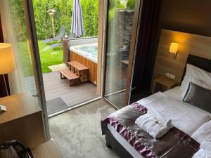a bedroom with a bed and a balcony with a tub at Villa Aruba & Private SPA Suites in Keszthely