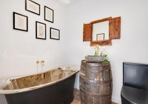 bañera en una habitación con TV y barril en Beal Bank Farm en Warkworth