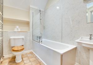 Baño blanco con aseo y lavamanos en Dunsdale House, en Kirknewton