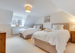 1 dormitorio con 2 camas y ventana en Dunsdale House, en Kirknewton