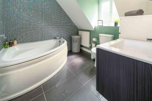 a bathroom with a white tub and a sink at Ideal Lodgings In Openshaw in Manchester