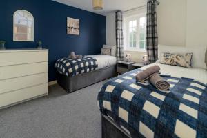 Duas camas num quarto com paredes azuis em Ideal Lodgings In Openshaw em Manchester