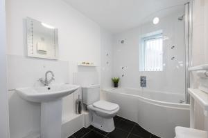 a white bathroom with a sink and a toilet at The Chorlton in Manchester
