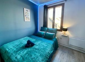 een slaapkamer met een groen bed en een groot raam bij L’Escale Dorée - Hyper Centre - 8 personnes in Barentin