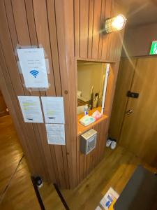 een kamer met een houten muur met borden erop bij 54Journey 東京大手町ホステル in Tokyo
