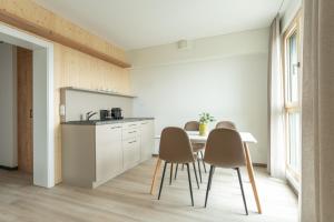 een keuken met een tafel en stoelen in een kamer bij eee Hotel Eberstalzell 