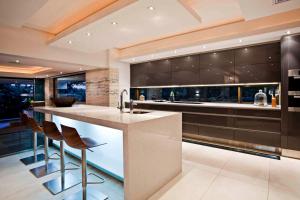 a kitchen with a counter with stools and a bar at étoile brillante du matin in Sandton