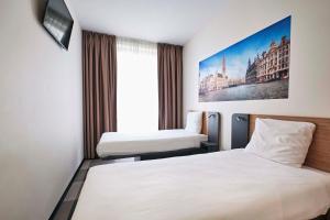 um quarto de hotel com duas camas e um quadro na parede em easyHotel Brussels City Centre em Bruxelas