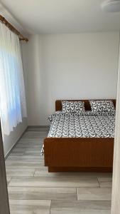a bedroom with a bed and a window at Apartments Linic in Nin