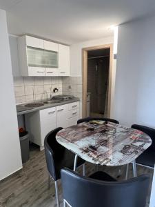 a kitchen with a table and chairs in a room at Apartments Linic in Nin