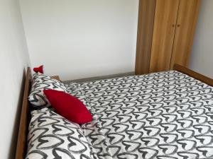 a bed with two red pillows in a bedroom at Apartments Linic in Nin