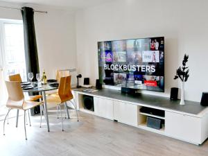 un salon avec une table et une grande télévision dans l'établissement Pass the Keys Free Parking Central Apartment, à Manchester