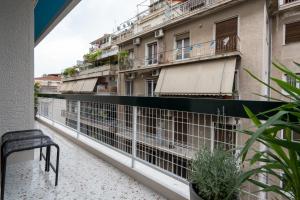einen Balkon mit einer schwarzen Bank und einigen Gebäuden in der Unterkunft Artistic Retreat in Athens heart in Athen