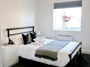 Pass the Keys Free Parking Central Apartment في مانشستر: غرفة نوم بسرير كبير عليها حشره محشوة
