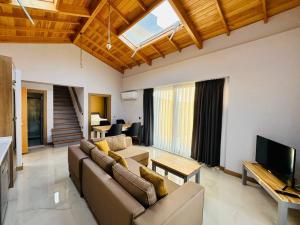 ein Wohnzimmer mit einem Sofa und einem TV in der Unterkunft Dreamy Vacation Villa with Pool in Kalkan Antalya in Kalkan