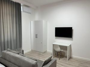 a living room with a couch and a table and a tv at Жилой Комплекс Акжайык in Astana