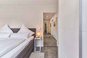 a bedroom with a bed and a lamp on a table at Haus Deepensoll 39 Ankerplatz in Pelzerhaken
