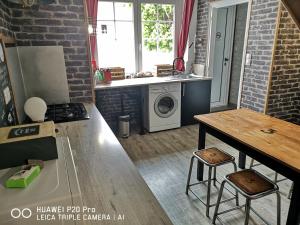 a kitchen with a table and a washing machine at Gîte les Hortensias in Marquise