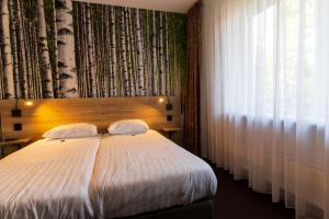 una camera con un grande letto e una finestra di Hotel de Stoppelberg a Beekbergen