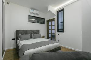 a white bedroom with a bed and a window at Luxe Apartment in Center in Yerevan