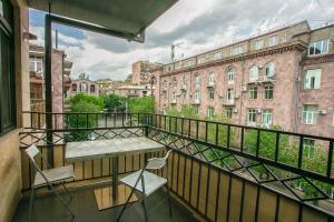 a balcony with a table and chairs and buildings at Luxe Apartment in Center in Yerevan
