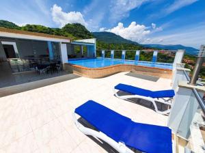 a house with a swimming pool and blue lounge chairs at Apartamentos vacacionales San Gil Plaza in San Gil
